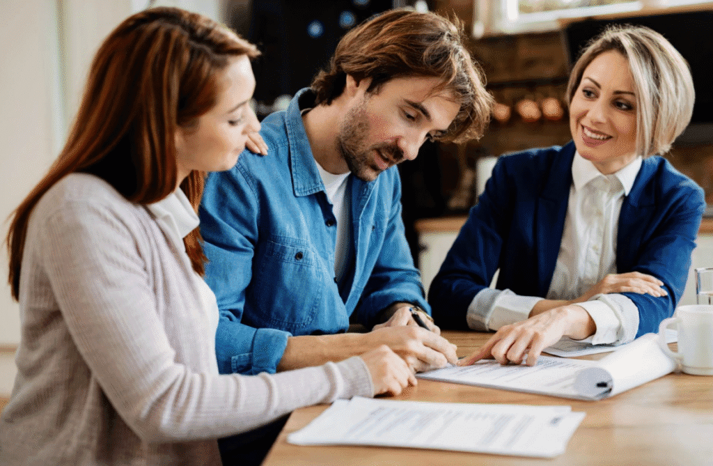 Frau zeigt zwei Personen, wo sie unterschreiben müssen